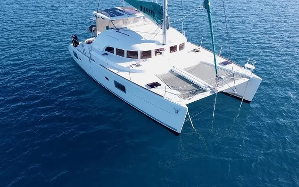 Majik from above on deep blue water, trampoline between the bows