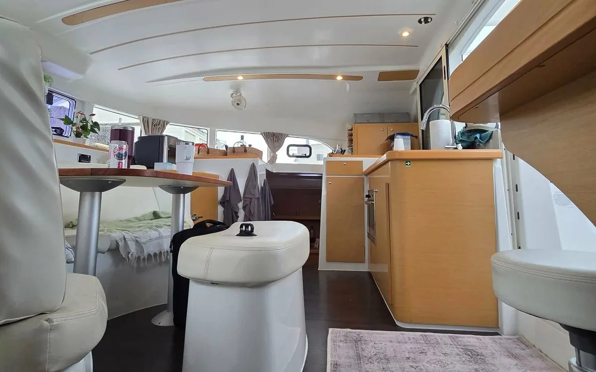 Majik’s salon: cream seating, the dining table, wood-trimmed galley
